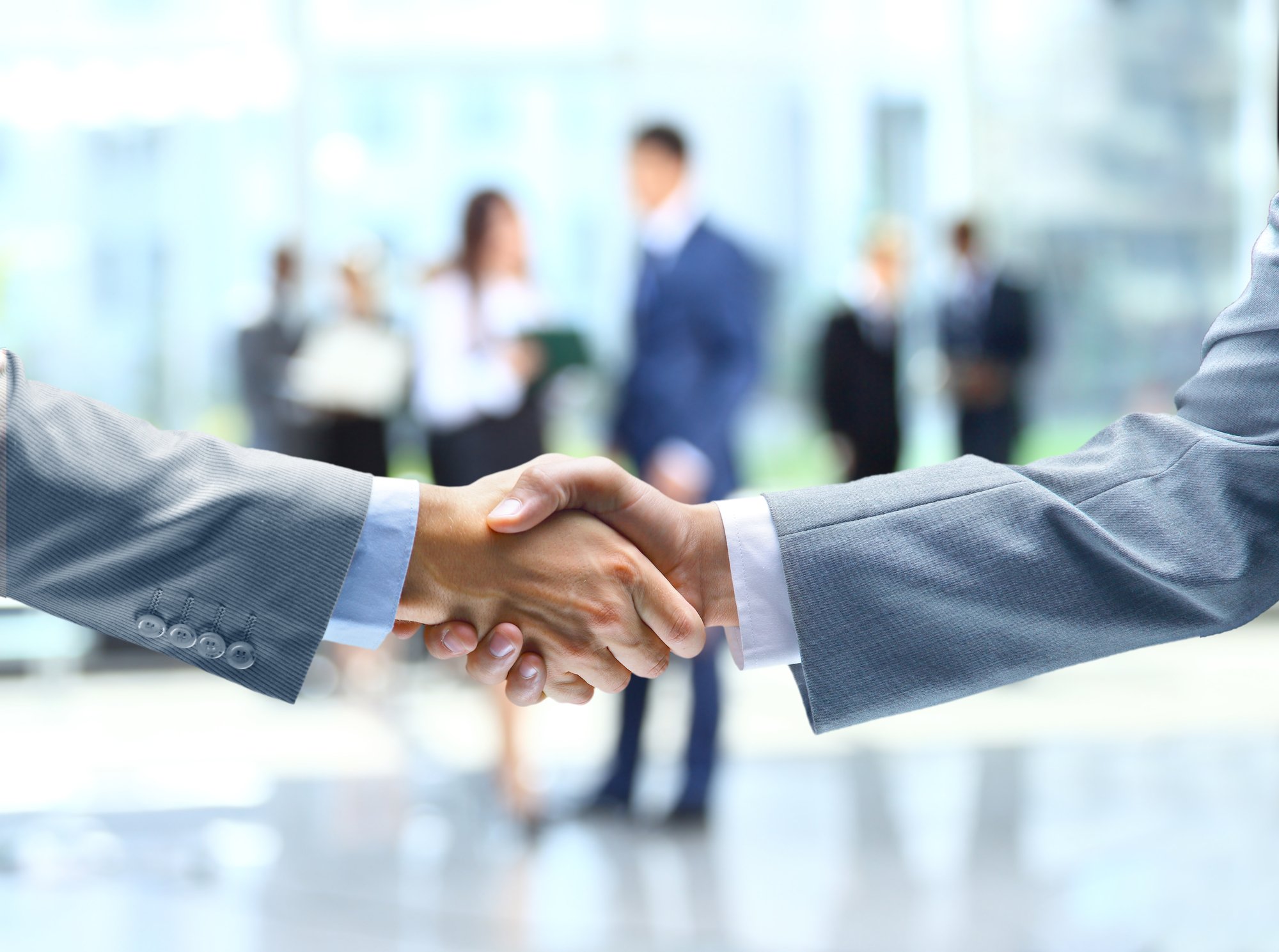 Immobilienverwalter geben sich nach erfolgreichem Training die Hand.