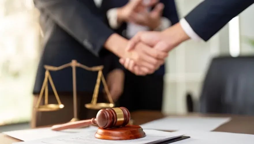 Richterhammer und Händedruck: rechtliche Einigung zu Nebenkosten